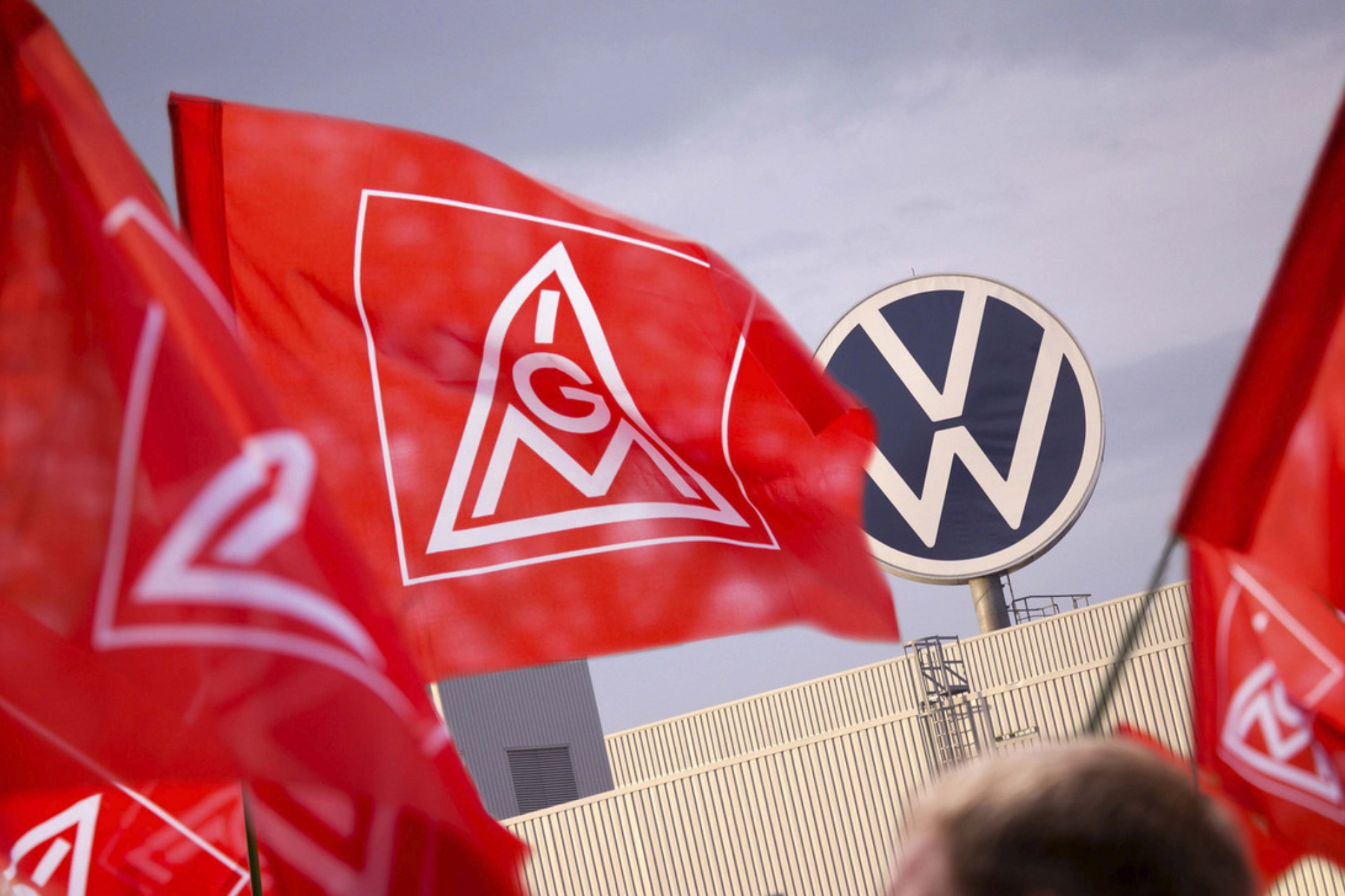 IG Metall-Fahnen vor dem Volkswagen-Logo
